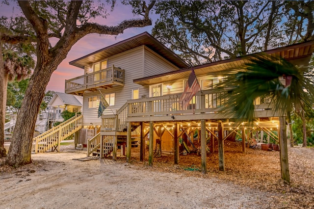 back house at dusk featuring a deck