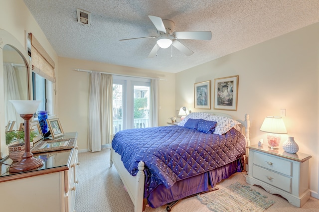 bedroom with ceiling fan, a textured ceiling, and light colored carpet