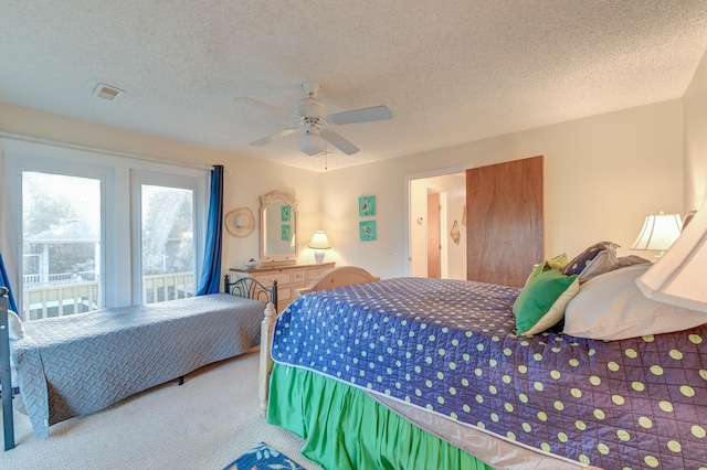 carpeted bedroom with ceiling fan and a textured ceiling