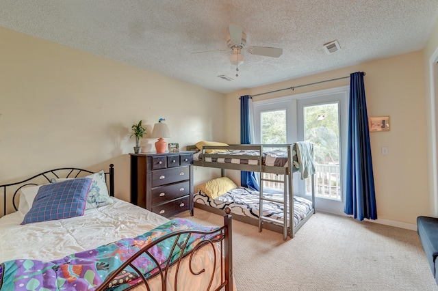 bedroom featuring a textured ceiling, light carpet, and ceiling fan