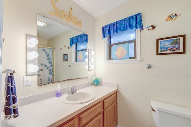 bathroom with vanity, a textured ceiling, toilet, and a shower with curtain