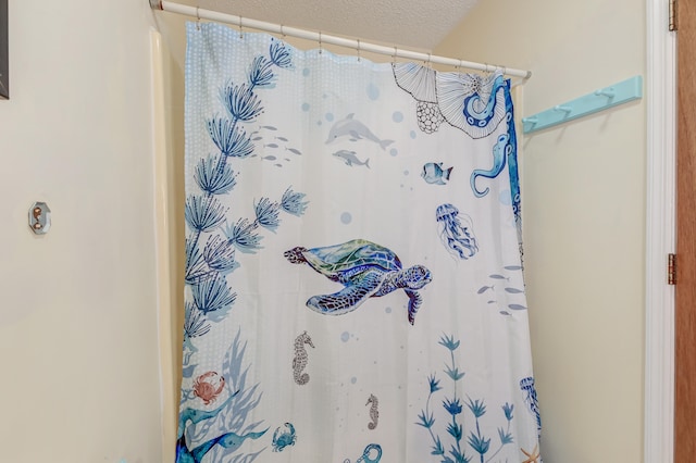 bathroom featuring curtained shower and a textured ceiling