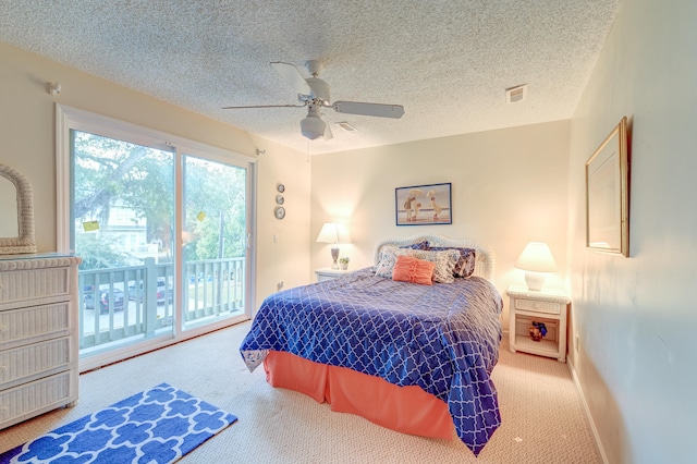 carpeted bedroom featuring access to outside, a textured ceiling, and ceiling fan