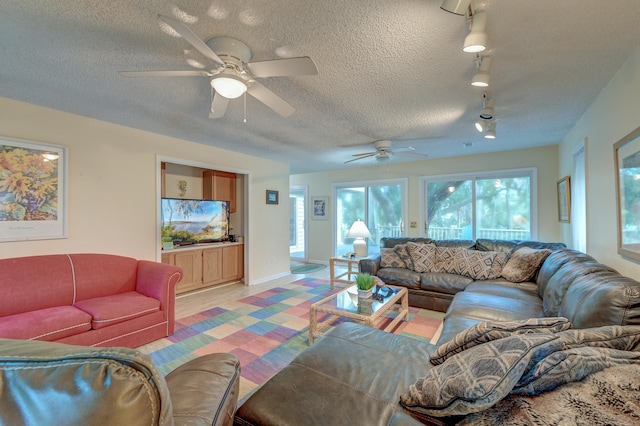 living room featuring a textured ceiling, track lighting, light hardwood / wood-style flooring, and ceiling fan