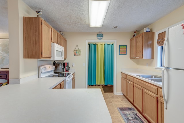 kitchen with sink, white appliances, a textured ceiling, and light tile patterned floors