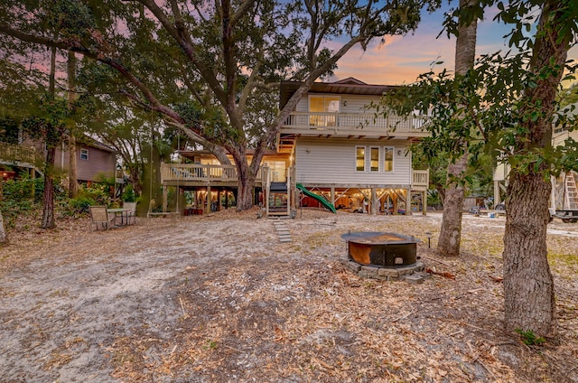 back house at dusk featuring a wooden deck