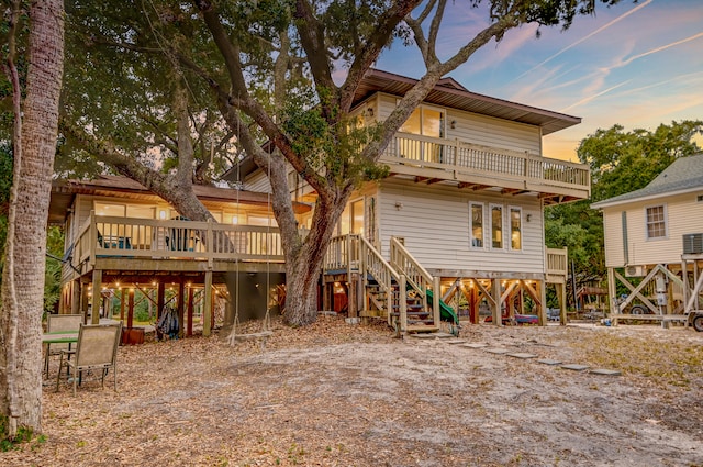 back house at dusk with a wooden deck