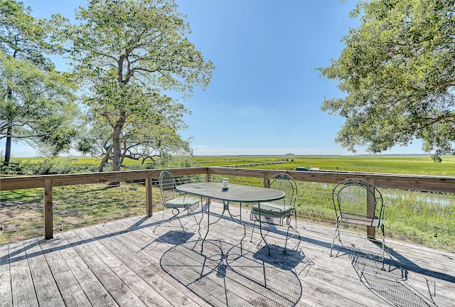 wooden deck with a yard and a rural view