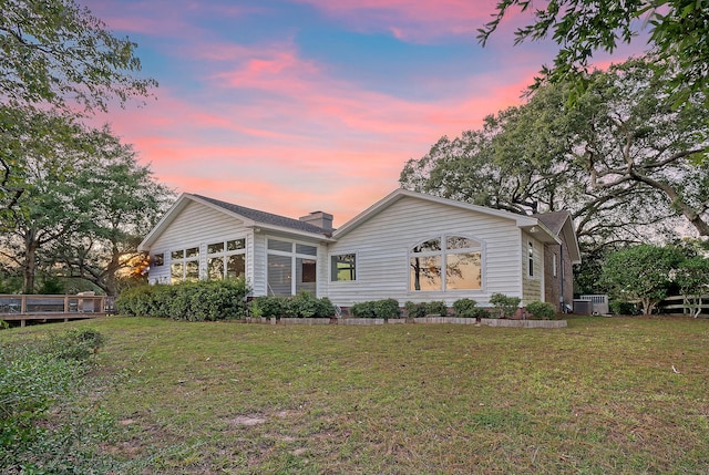 rear view of house featuring a yard and central air condition unit