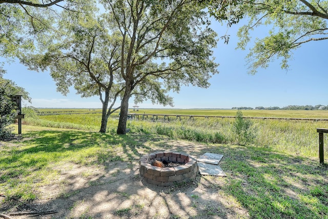 view of yard featuring an outdoor fire pit and a rural view