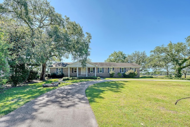 view of front facade featuring driveway and a front yard