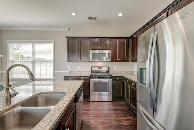 8038 Regency Elm Dr, North Charleston, SC 29406 - kitchen featuring stainless steel appliances, a sink, dark brown cabinets, ornamental molding, and dark wood-style flooring