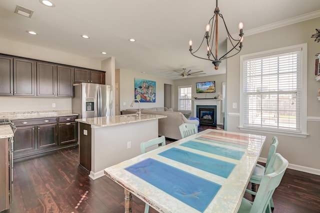 8038 Regency Elm Dr, North Charleston, SC 29406 - dining area featuring a glass covered fireplace, dark wood-type flooring, a chandelier, baseboards, and recessed lighting