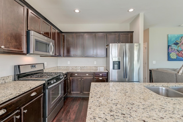 8038 Regency Elm Dr, North Charleston, SC 29406 - kitchen with stainless steel appliances, dark brown cabinets, dark wood finished floors, light stone countertops, and recessed lighting