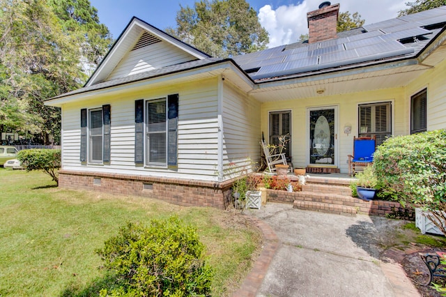 view of front facade with solar panels, a front yard, and a porch