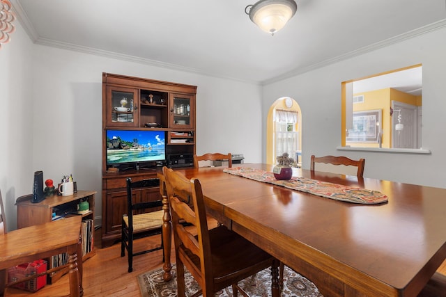 dining area with arched walkways, visible vents, ornamental molding, and hardwood / wood-style floors