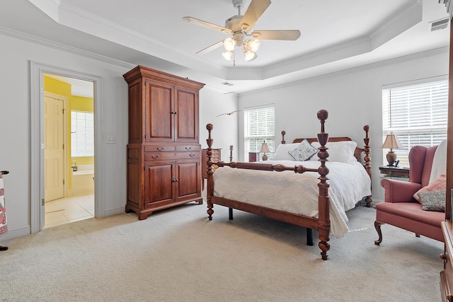 bedroom featuring crown molding, a tray ceiling, light carpet, and visible vents