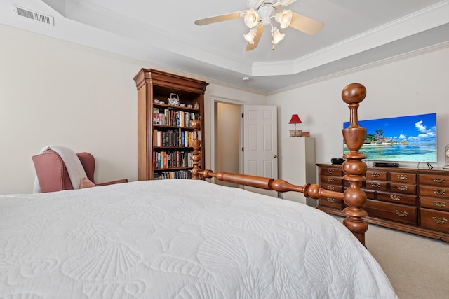carpeted bedroom featuring a raised ceiling, ornamental molding, ceiling fan, and visible vents