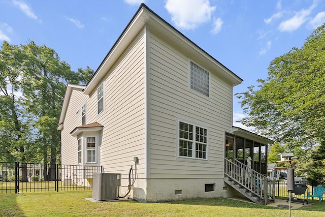 view of side of home with fence, stairway, crawl space, cooling unit, and a lawn