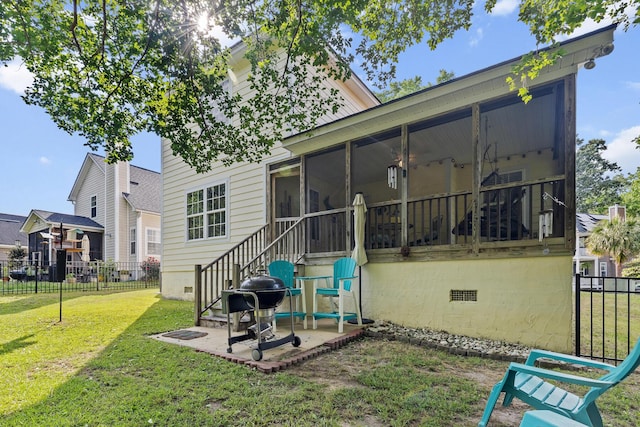 back of property with fence, a sunroom, crawl space, a patio, and a yard