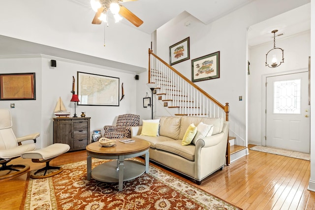 living room featuring crown molding, ceiling fan, hardwood / wood-style flooring, and stairs