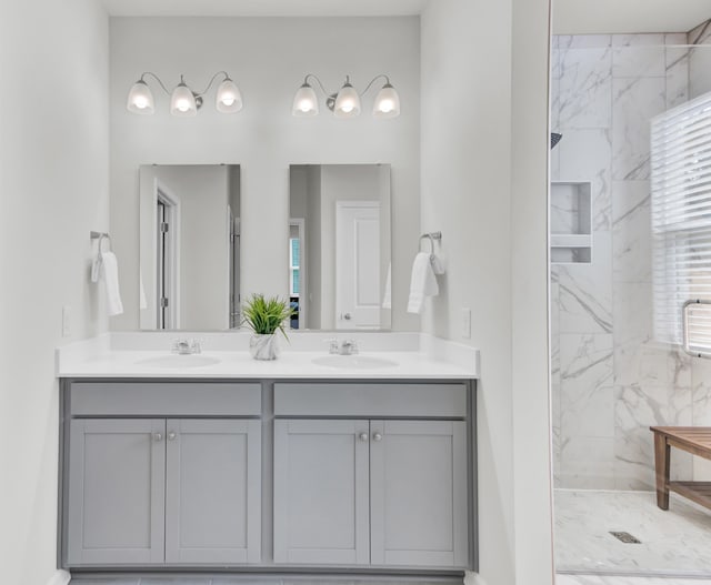 bathroom featuring tiled shower and vanity