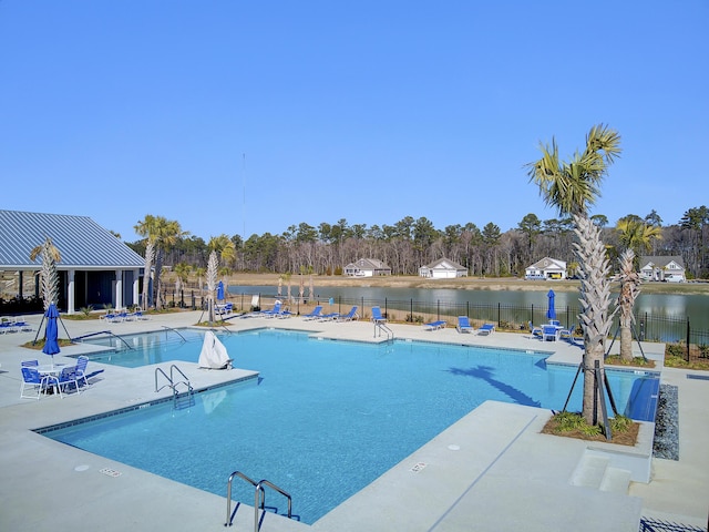 view of swimming pool with a patio area and a water view