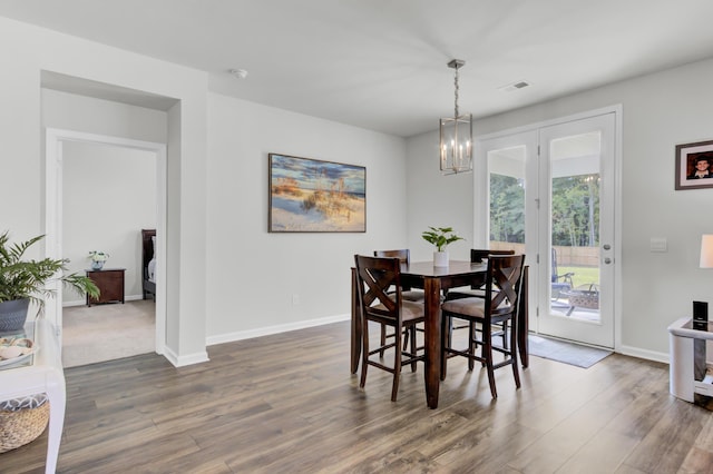 dining area featuring a notable chandelier and dark wood-type flooring