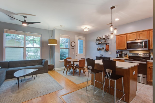 5134 E Liberty Park Cir N, Charleston, SC 29405 - kitchen featuring appliances with stainless steel finishes, a center island, light countertops, light wood-style flooring, and a breakfast bar area
