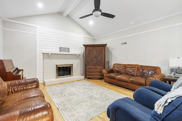 living room with visible vents, lofted ceiling with beams, wood finished floors, a fireplace, and ceiling fan