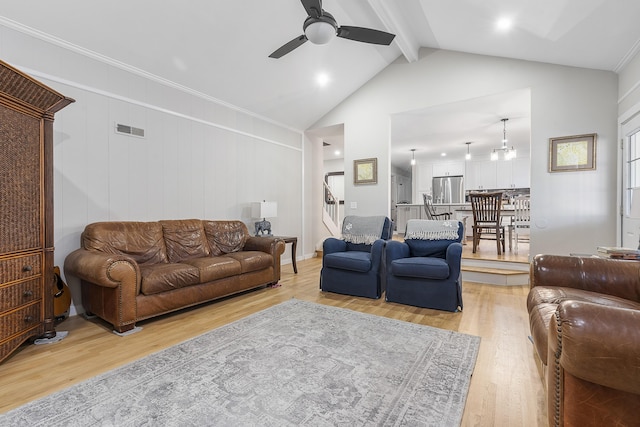 living room featuring visible vents, beamed ceiling, high vaulted ceiling, a ceiling fan, and light wood-style floors