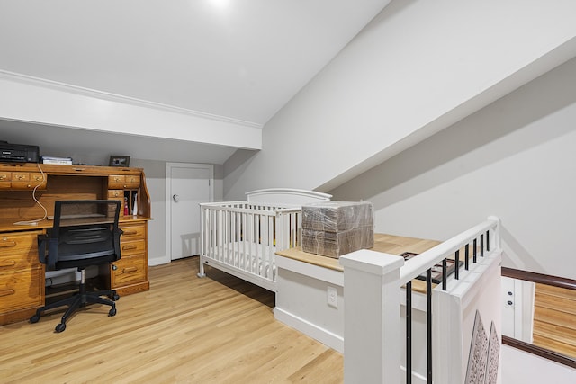 bedroom with light wood-style flooring, baseboards, and vaulted ceiling