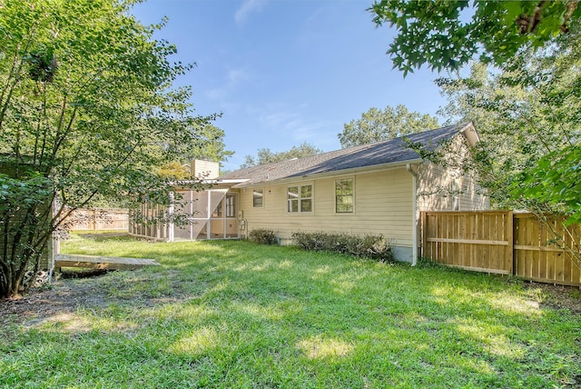 rear view of property with a yard, roof with shingles, a chimney, and fence