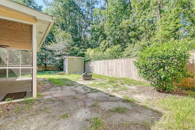 view of yard with an outbuilding, a patio area, a storage unit, and a fenced backyard