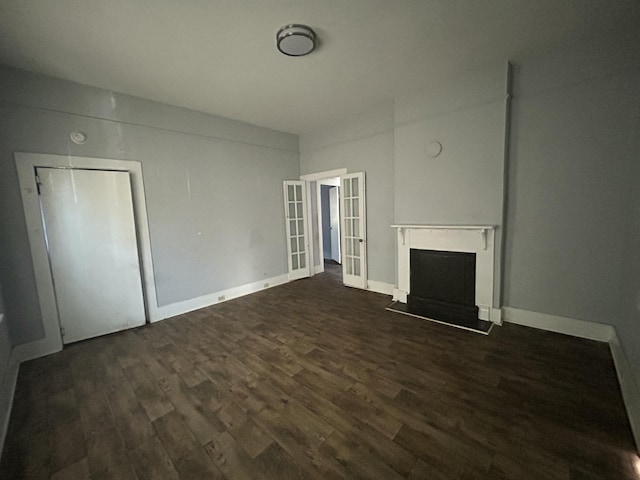 unfurnished living room featuring dark hardwood / wood-style floors and french doors