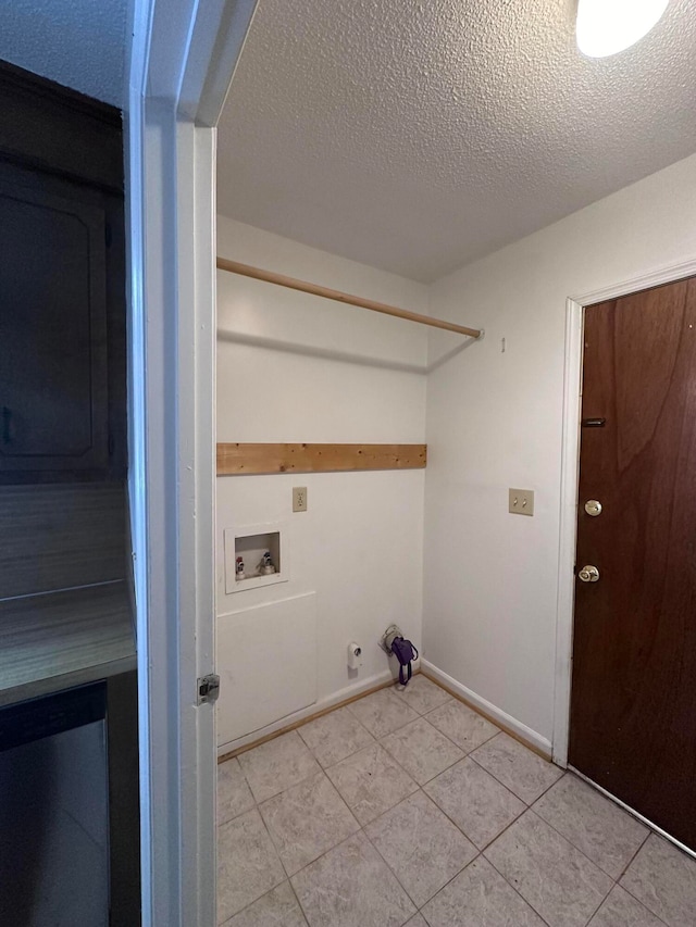 washroom featuring washer hookup, a textured ceiling, light tile floors, and gas dryer hookup