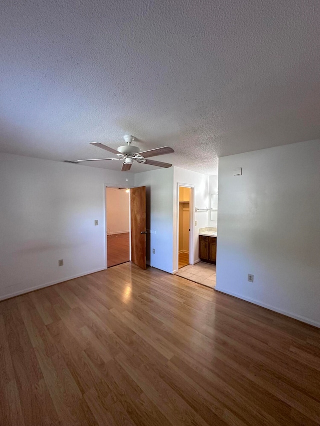 tiled empty room featuring ceiling fan and a textured ceiling