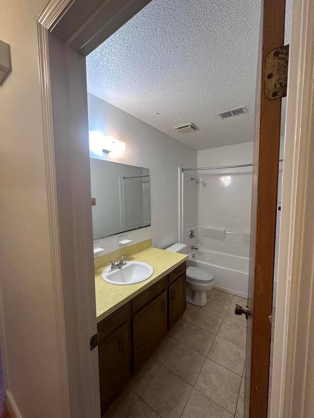 full bathroom featuring oversized vanity, toilet, a textured ceiling, washtub / shower combination, and tile floors