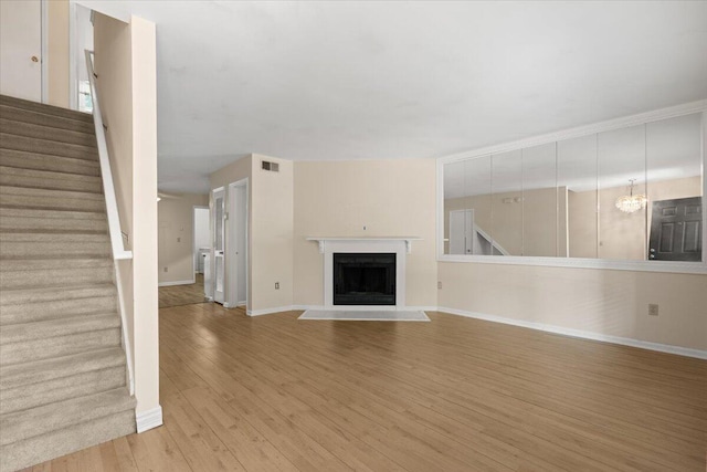 1383 Camp Rd Unit C, Charleston, SC 29412 - unfurnished living room with light wood-style flooring, stairway, and a fireplace with flush hearth