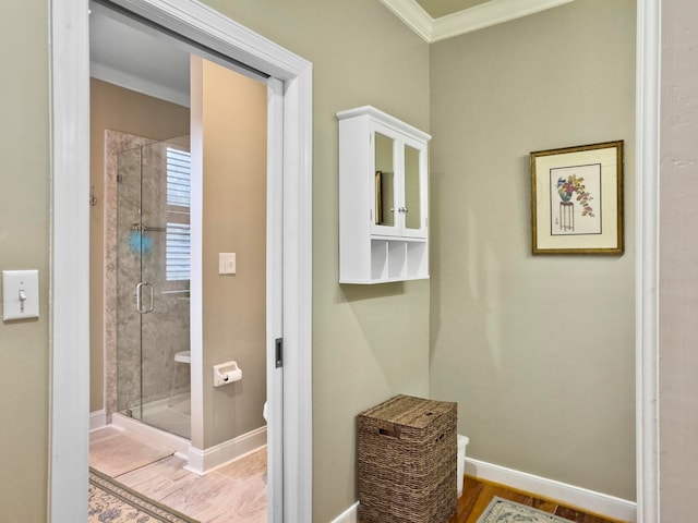 bathroom featuring ornamental molding, a shower with shower door, and hardwood / wood-style floors