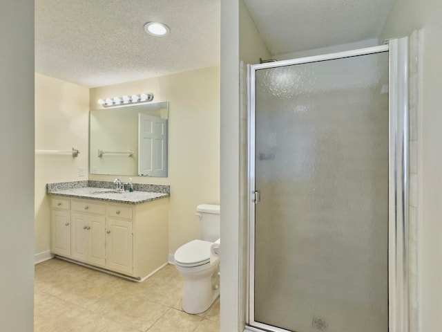 bathroom featuring tile patterned flooring, toilet, a shower with door, and vanity