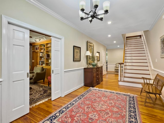 interior space with track lighting, crown molding, hardwood / wood-style flooring, and a notable chandelier