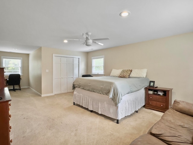 carpeted bedroom featuring ceiling fan and a closet