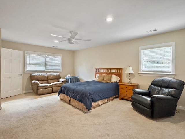 carpeted bedroom with ceiling fan and multiple windows