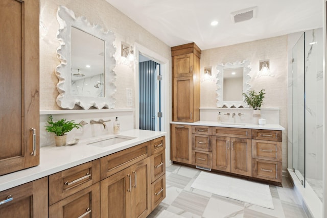 bathroom featuring a shower with door and vanity