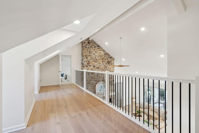 additional living space featuring ceiling fan, light hardwood / wood-style flooring, and vaulted ceiling with beams