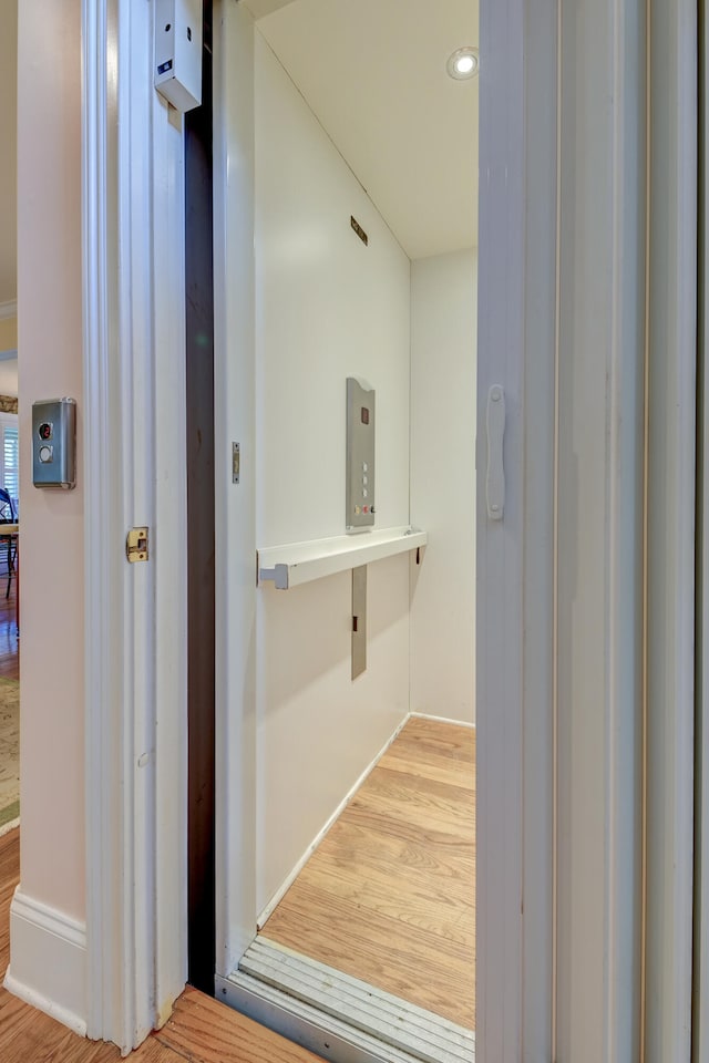 bathroom with hardwood / wood-style floors and elevator