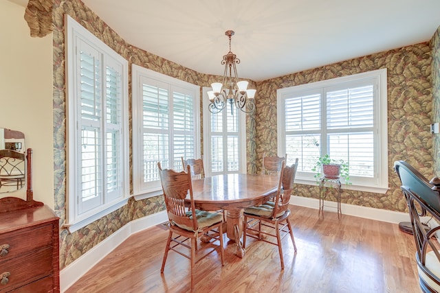 dining room with light hardwood / wood-style floors and a notable chandelier