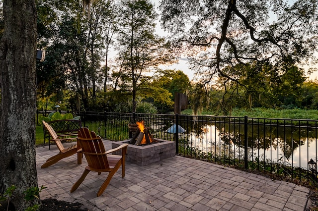 view of patio with a water view and a fire pit