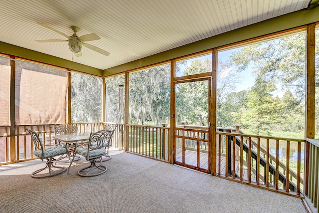 unfurnished sunroom with ceiling fan